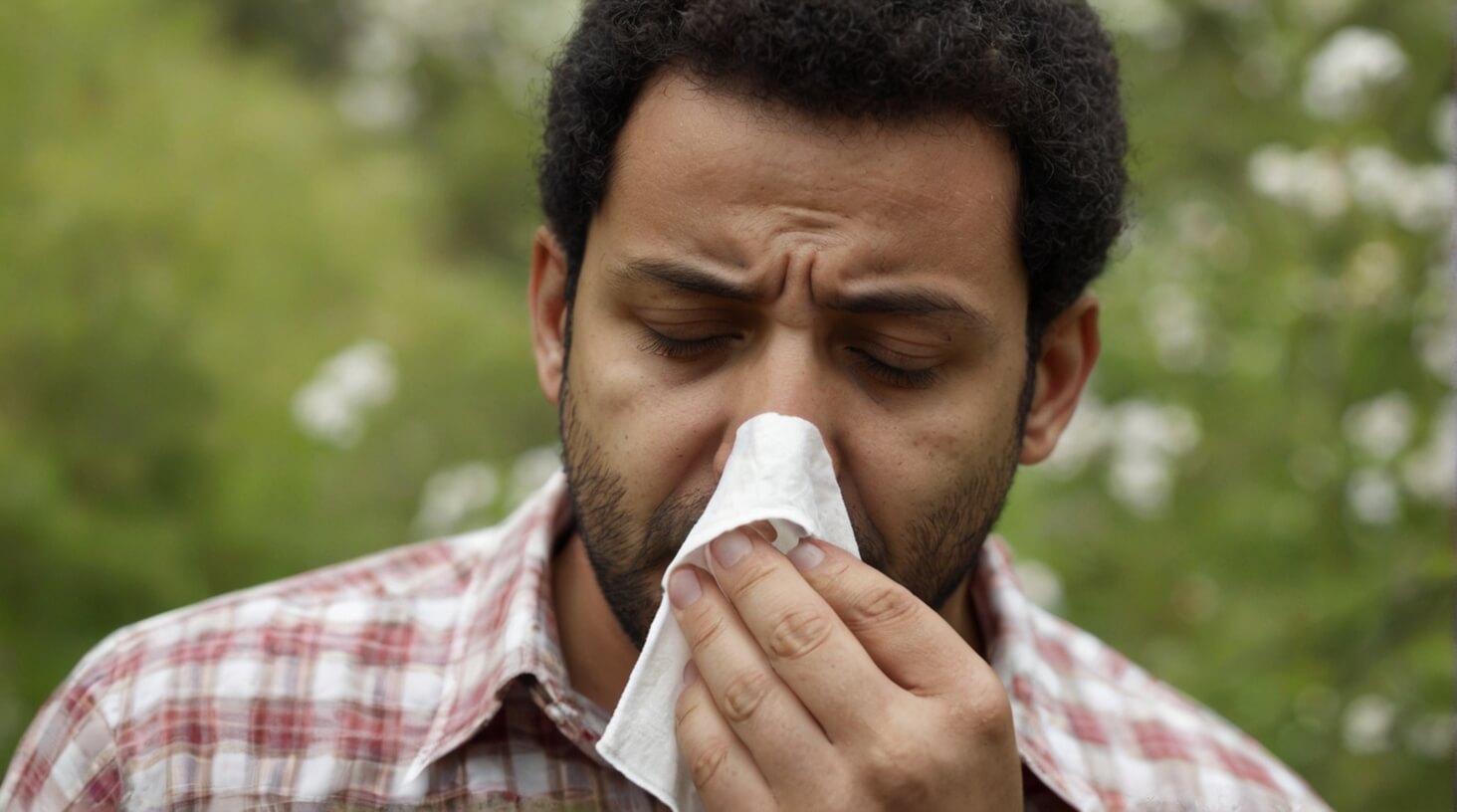Image depicting a checklist with common allergy symptoms: runny nose, sneezing, itching, and watery eyes.
